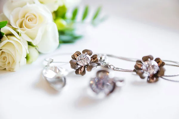 Photo of Jewelry and flowers on white background