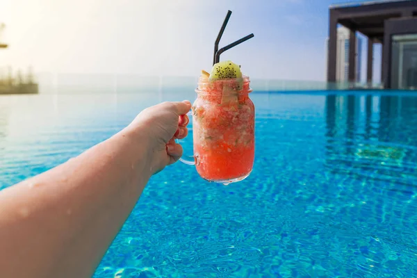 Foto Coquetel Frutas Mãos Meninas Fundo Uma Piscina — Fotografia de Stock