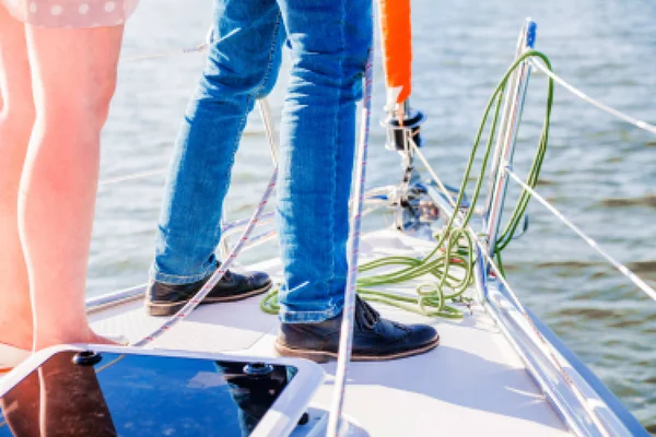 Een man en een vrouw staan op het dek van een jacht. — Stockfoto