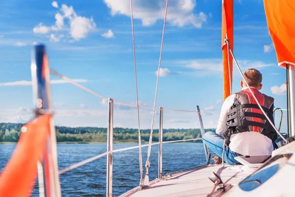 Young man on a boat in a life jacket — Stock Photo, Image