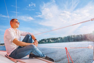 adam beyaz gömlek ve yat üzerinde güneş gözlüğü