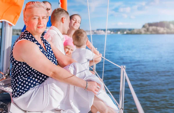 older woman enjoys sailing with her family