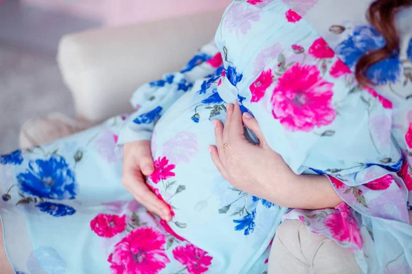 Mulher feliz grávida sentada na cadeira. Quarto em rosa pastel — Fotografia de Stock