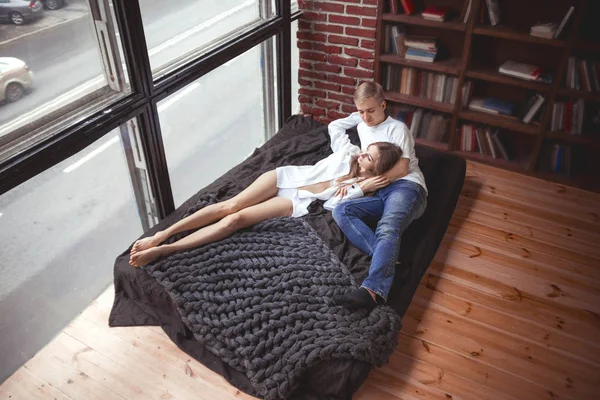 Joven pareja enamorada acostada en la cama y abrazándose —  Fotos de Stock