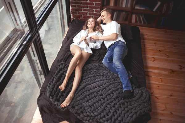 Genç erkek ve kadın yatakta yatmak ve iyi eğlenceler — Stok fotoğraf