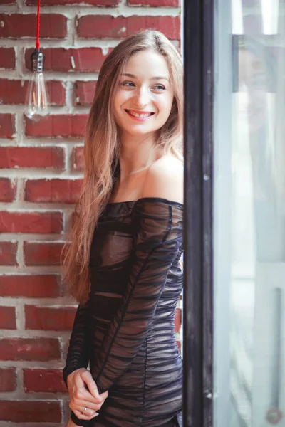 レンガの壁、ポージング イブニング ドレスで美しい少女 — ストック写真