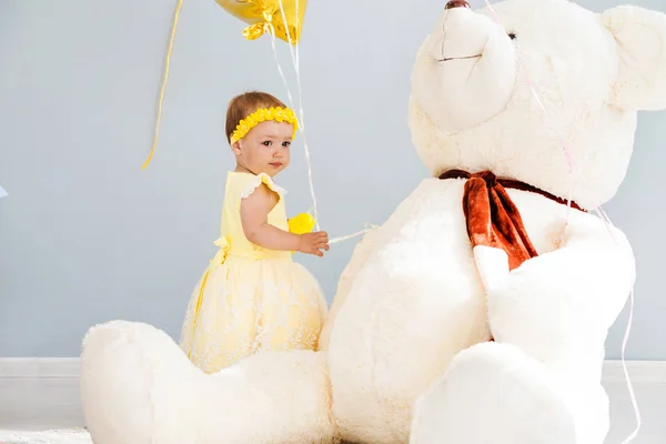 Bambina con palloncini e un grande orso bianco giocattolo — Foto Stock