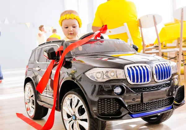 Minsk, Biélorussie - 30 janvier 2019. Petite fille conduisant une voiture jouet. Photo horizontale — Photo