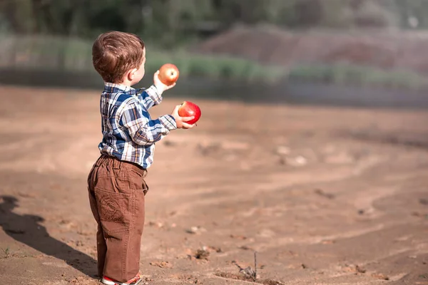 Petit garçon avec une pomme dans les mains — Photo