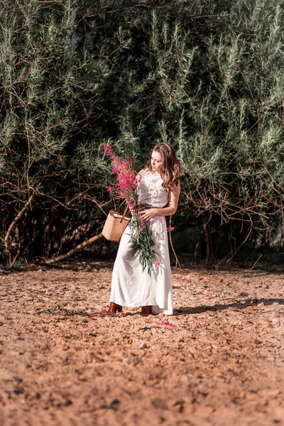 Chica con estilo con un ramo en la mano y una cesta —  Fotos de Stock