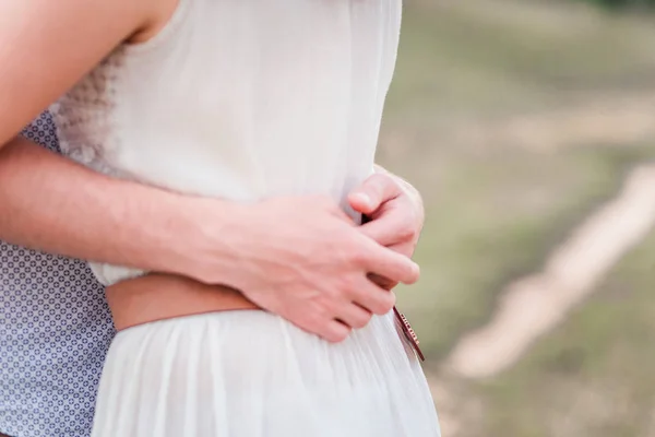 Um homem abraça uma mulher. Mãos ao alto — Fotografia de Stock