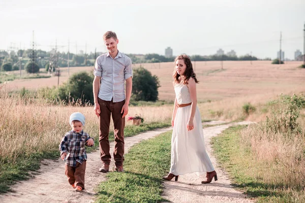 Famiglia felice in una passeggiata nel campo con il loro piccolo figlio — Foto Stock