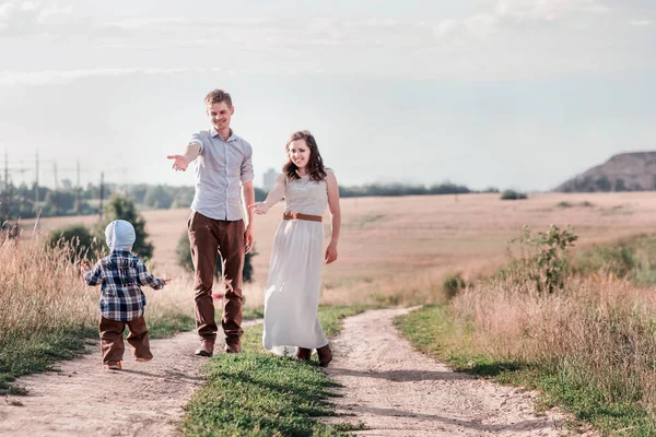 Happy family on a walk in the field with their little son — Stock Photo, Image