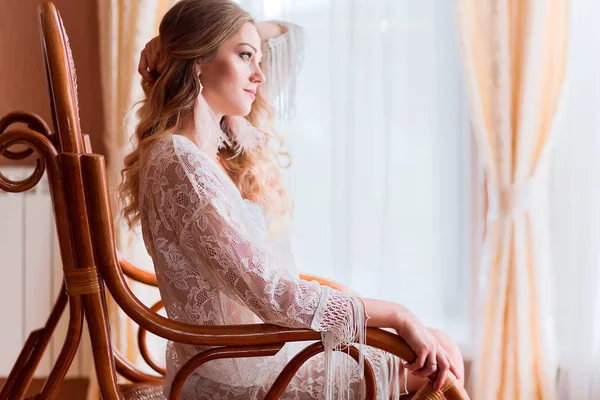 The girl in a peignoir sits in a rocking chair — Stock Photo, Image