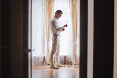 Bir adam bir düğme kol üzerinde takılır.