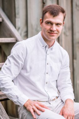 Eski ahşap merdiven üzerinde poz beyaz elbiseli damat