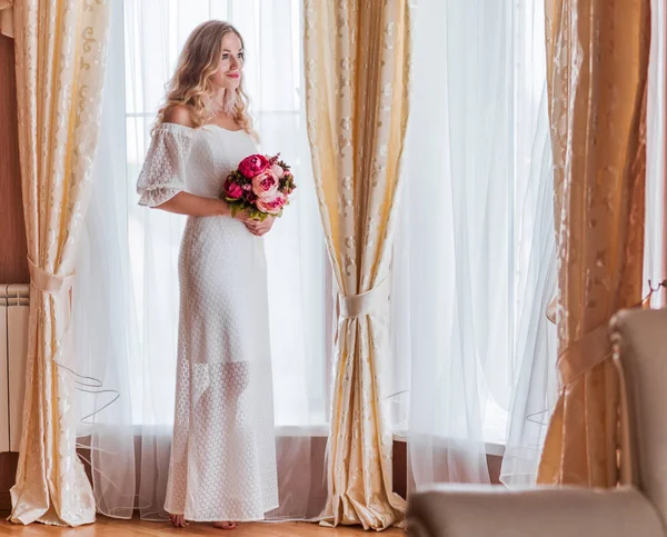 Novia con un ramo de flores cerca de la ventana —  Fotos de Stock