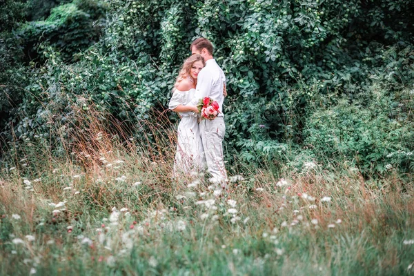 牡丹が森の背景にポーズのブーケと新郎新婦 — ストック写真