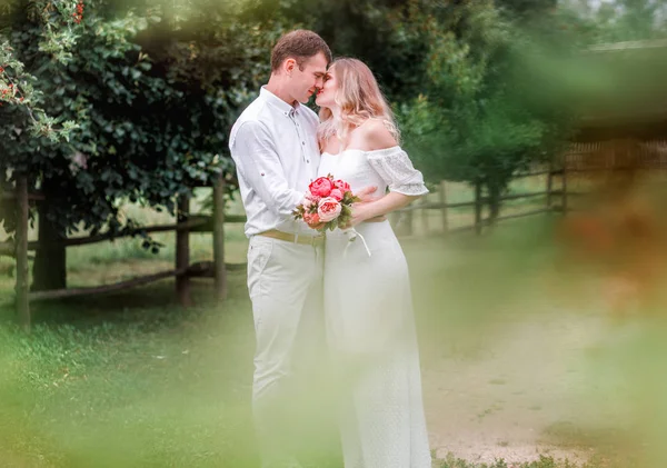 Braut und Bräutigam küssen sich. Bäume ringsum — Stockfoto