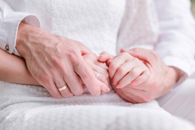 Bir adam yavaşça bir kadının elleri kucaklayan