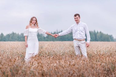 Gelin ve damat bir buğday alan arka plan üzerinde elele