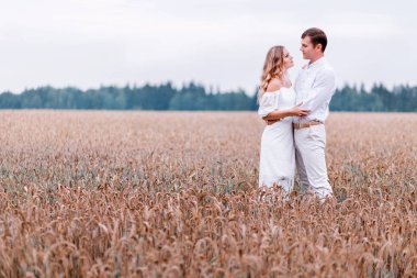 Gelin ve damat bir buğday alan fonunda poz