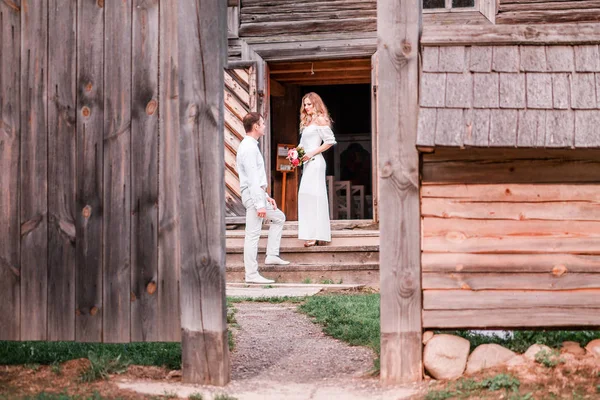 Bride and groom at the entrance to the wooden church