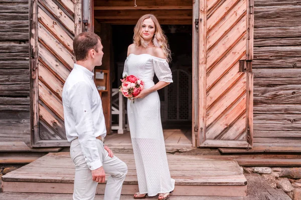 Bride and groom at the entrance to the wooden church