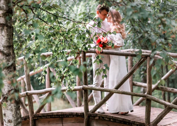 Γαμπρός νύφη να ποζάρουν για μια ξύλινη γέφυρα — Φωτογραφία Αρχείου