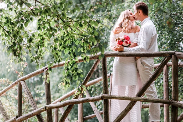 Bruidegom bruid poseren op een houten brug — Stockfoto