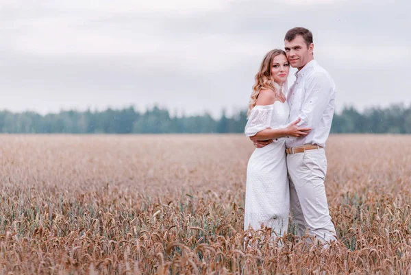 Bride and groom posing against the backdrop of a wheat field — Stock Photo, Image