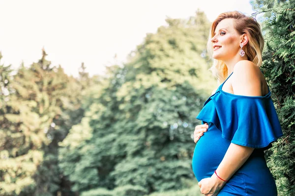 怀孕美丽的女人在公园里摆姿势 — 图库照片