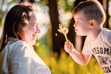 mutlu çocuk annelerin yüzüne karahindiba üfleme
