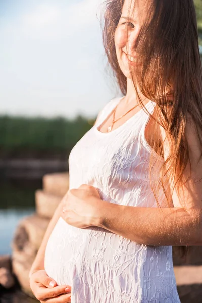 Feliz embarazada está abrazando su vientre —  Fotos de Stock