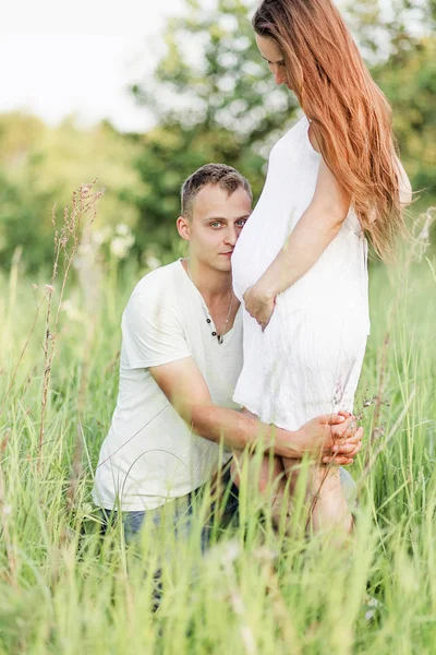 Gelukkige man omarmt zijn vrouws zwangere buik — Stockfoto