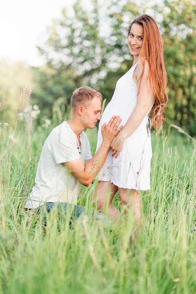 未来的父亲拥抱和亲吻他的妻子怀孕的肚子 — 图库照片
