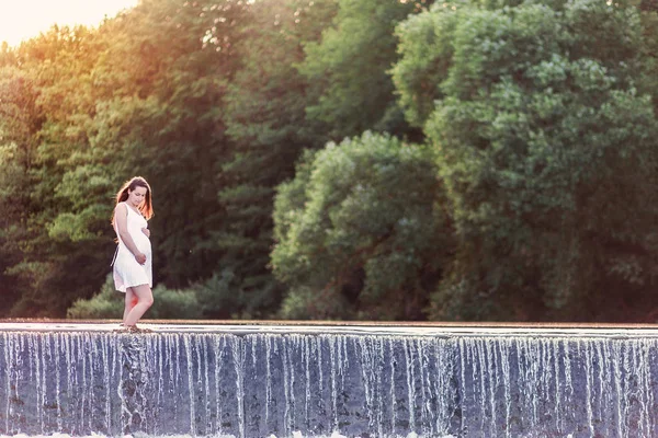 美丽的孕妇站在河里摆姿势 — 图库照片