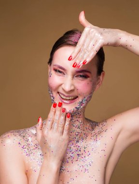 Trendy glitter makyaj ile Mutlu model kadın onu çivi göstermek