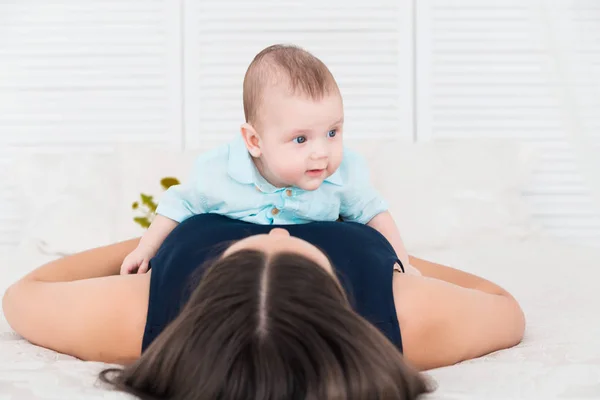 Mère heureuse posée sur le ventre de son petit fils — Photo