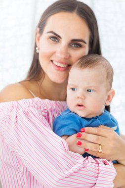 güzel anne kollarında küçük bir oğul tutar