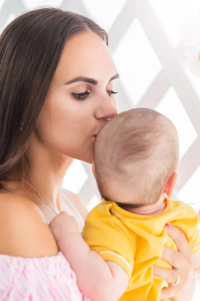 Belle jeune mère embrasse son petit fils — Photo