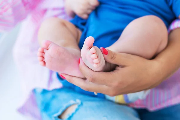 Mom holds her sweet little son legs — Stock Photo, Image