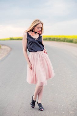 şık kız modeli bir tül etek ve siyah üst yolda poz