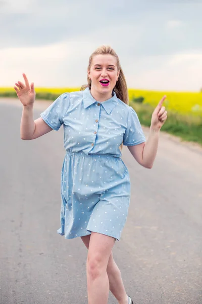 girl model jumping on the road and screaming with happiness