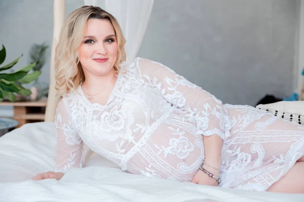 Glückliche Frau im weißen Kleid liegt auf dem Bett — Stockfoto