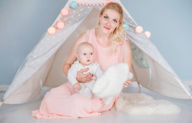 anne bir çocuk çadırı yakınında bir odada oğlu ile oynar