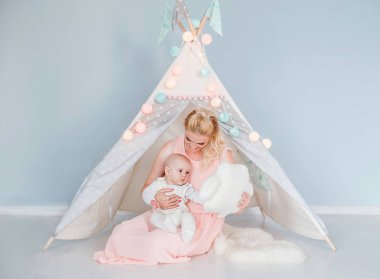 anne bir çocuk çadırı yakınında bir odada oğlu ile oynar