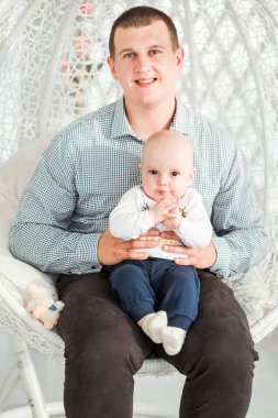 baba ve oğlu yuvarlak bir şık sandalyede oturuyor