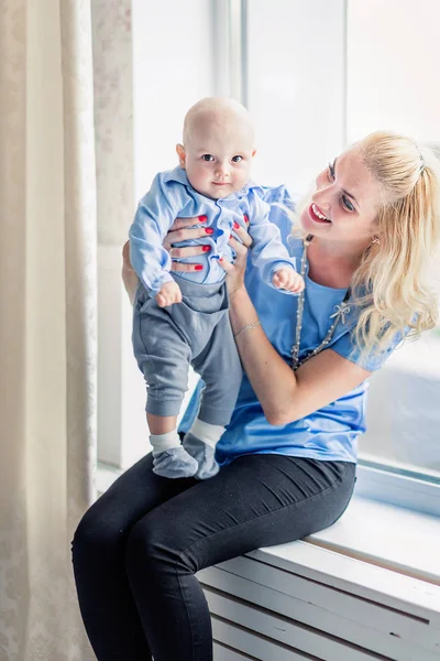 Mère avec son petit fils sont assis sur le rebord de la fenêtre — Photo