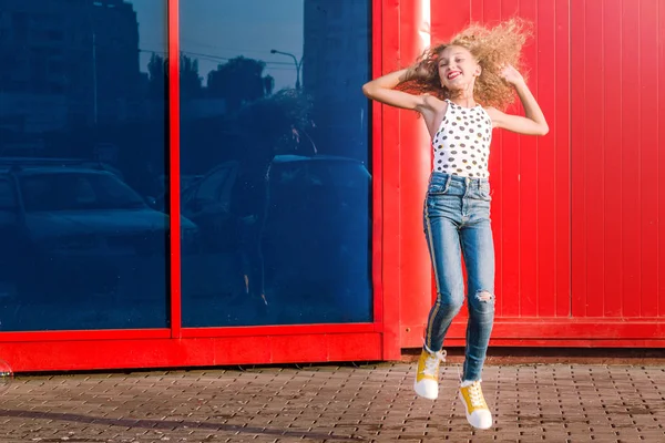 Heureuse adolescente posant sur un fond de mur rouge-bleu. Photo pleine longueur — Photo